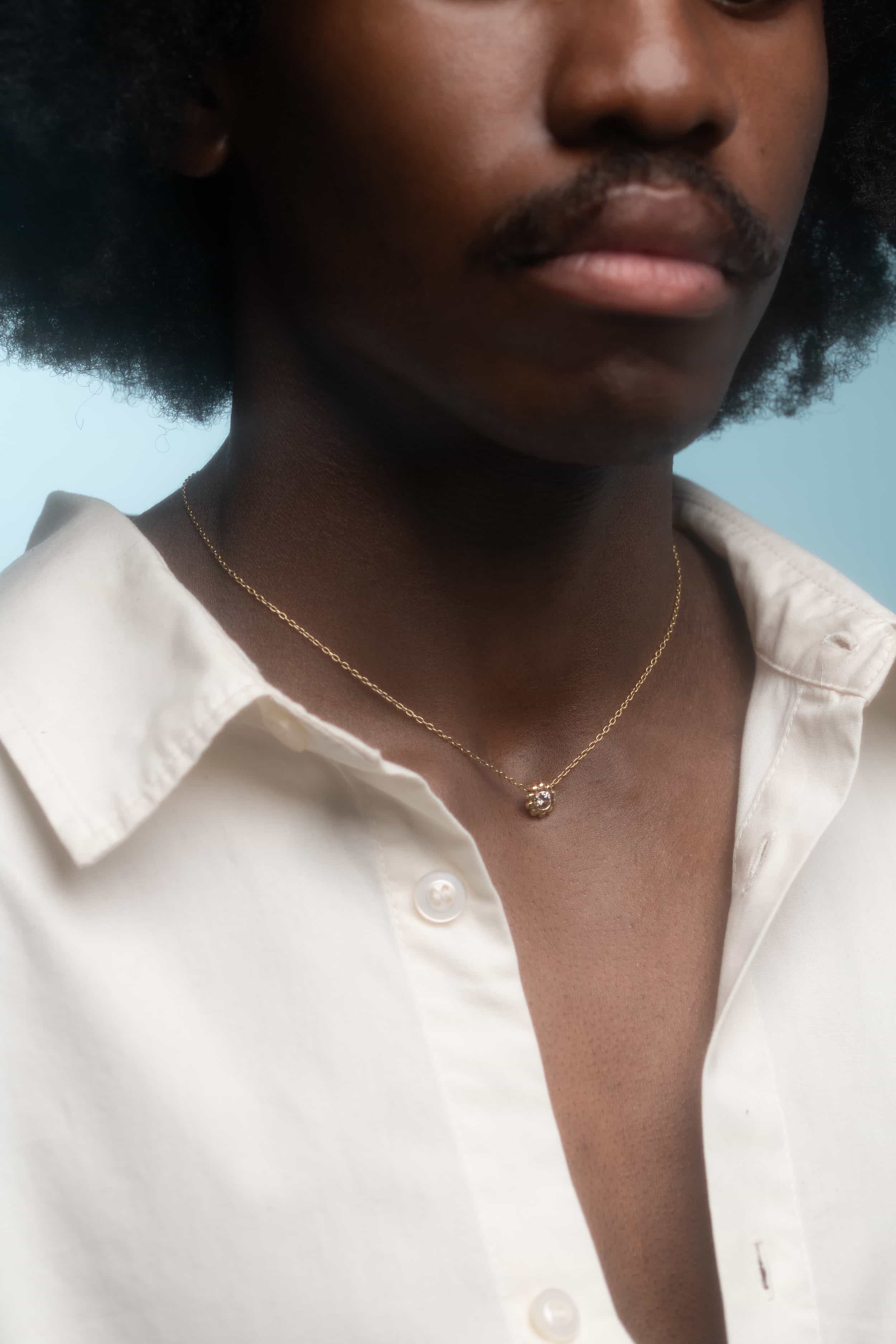 Model wears Skull Drop Down Pendant in 18k Red Gold