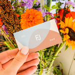 Model holds a Fitzgerald Jewelry gift card in front of a flower bouqet