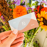 Model holds a Fitzgerald Jewelry gift card in front of a flower bouqet