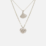 Front view of Ginkgo Necklace in 14k white gold and Lotus Necklace in 14k white gold hanging together