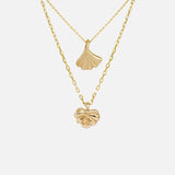 Front view of Ginkgo Necklace in 14k yellow gold and Lotus Necklace in 14k yellow gold hanging together