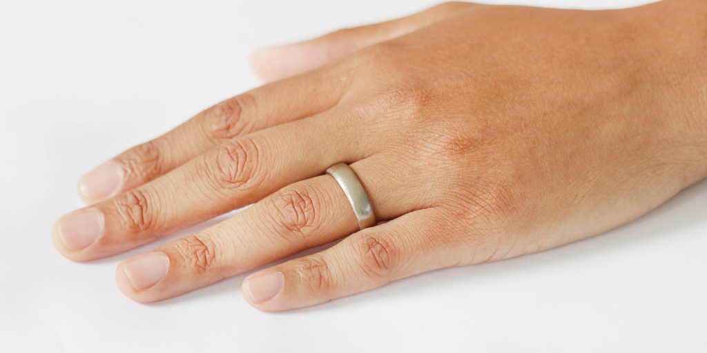 Model wears Dome Band / 6mm in 14k Grey Gold on ring finger