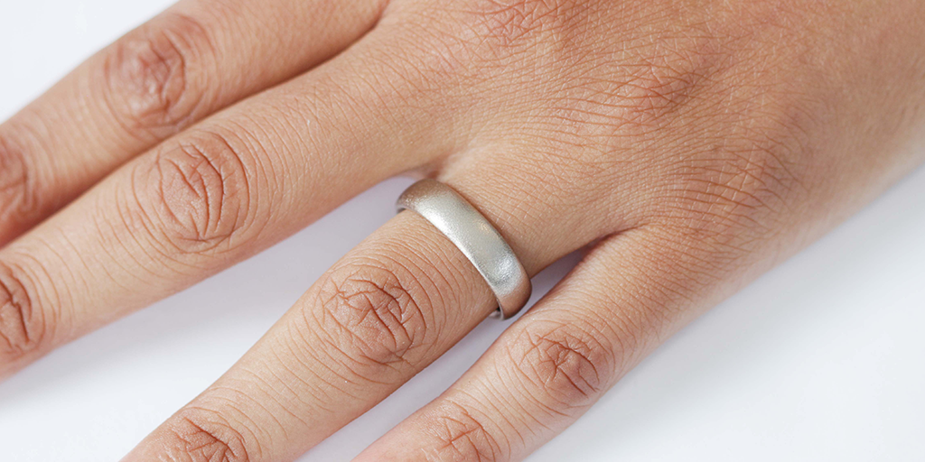 Model wears Dome Band / 6mm in 14k Grey Gold on ring finger