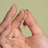 Model holds a single Ruby Skull Drop Earring