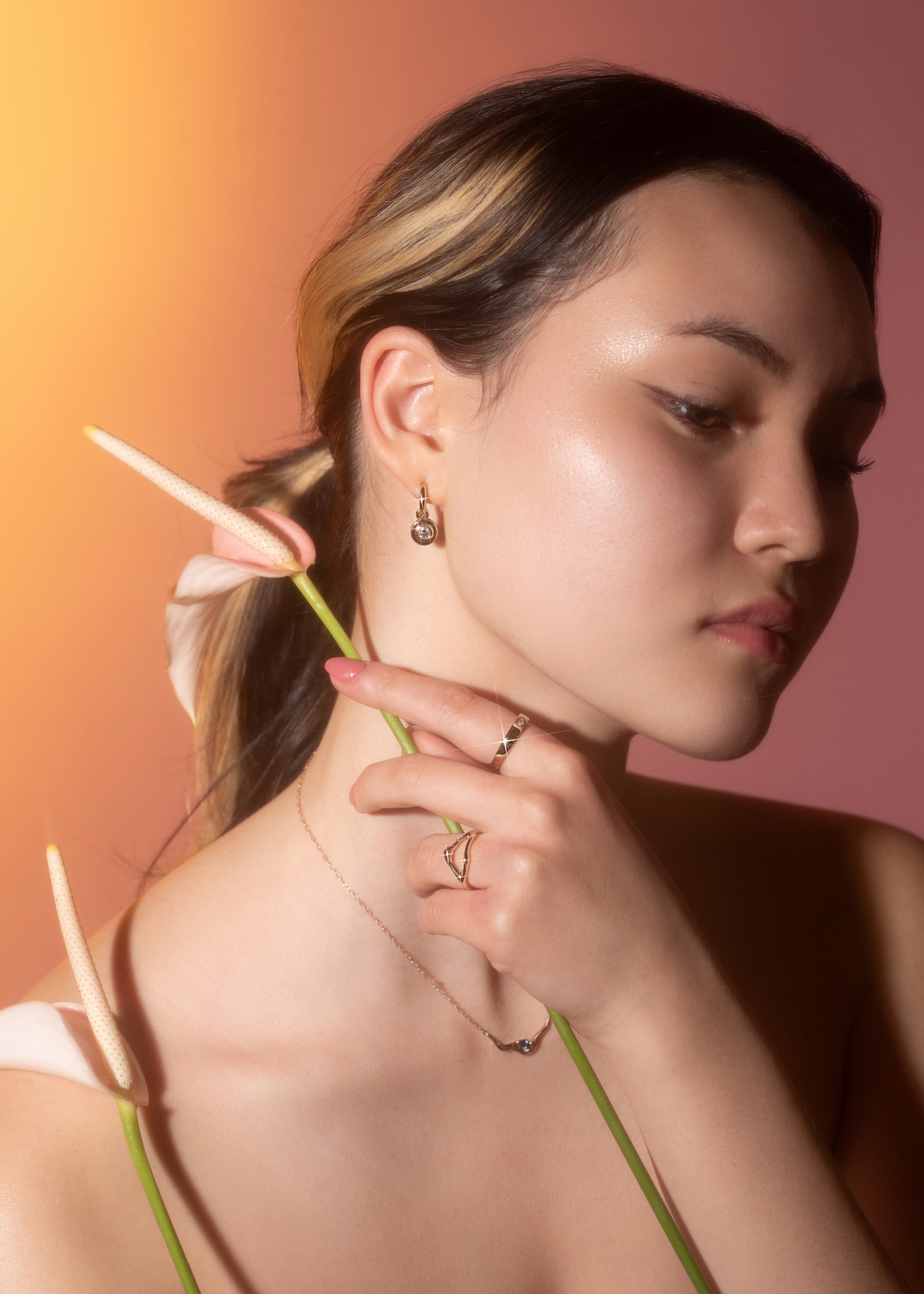 Model wears Kestrel Dillion's Pear Dip Necklace on neck, Tricia Kirkland's Hoop / Diamond Drops in ear, Kestrel Dillion's Split Root Ring on ring finger, and Young Son Song's Sparkling Crescent Band on index finger
