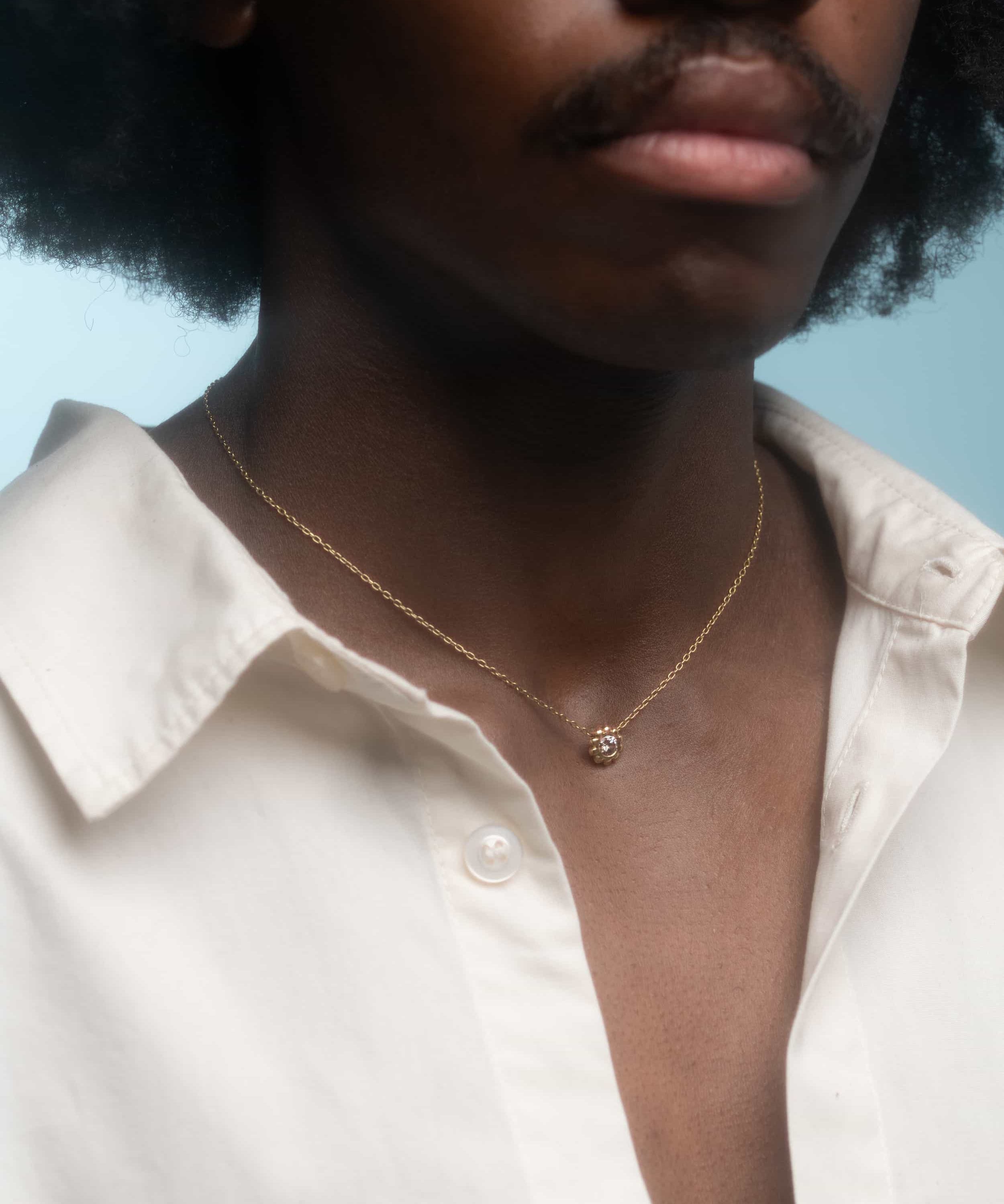 Model wears Skull Drop Down Pendant in 18k Red Gold