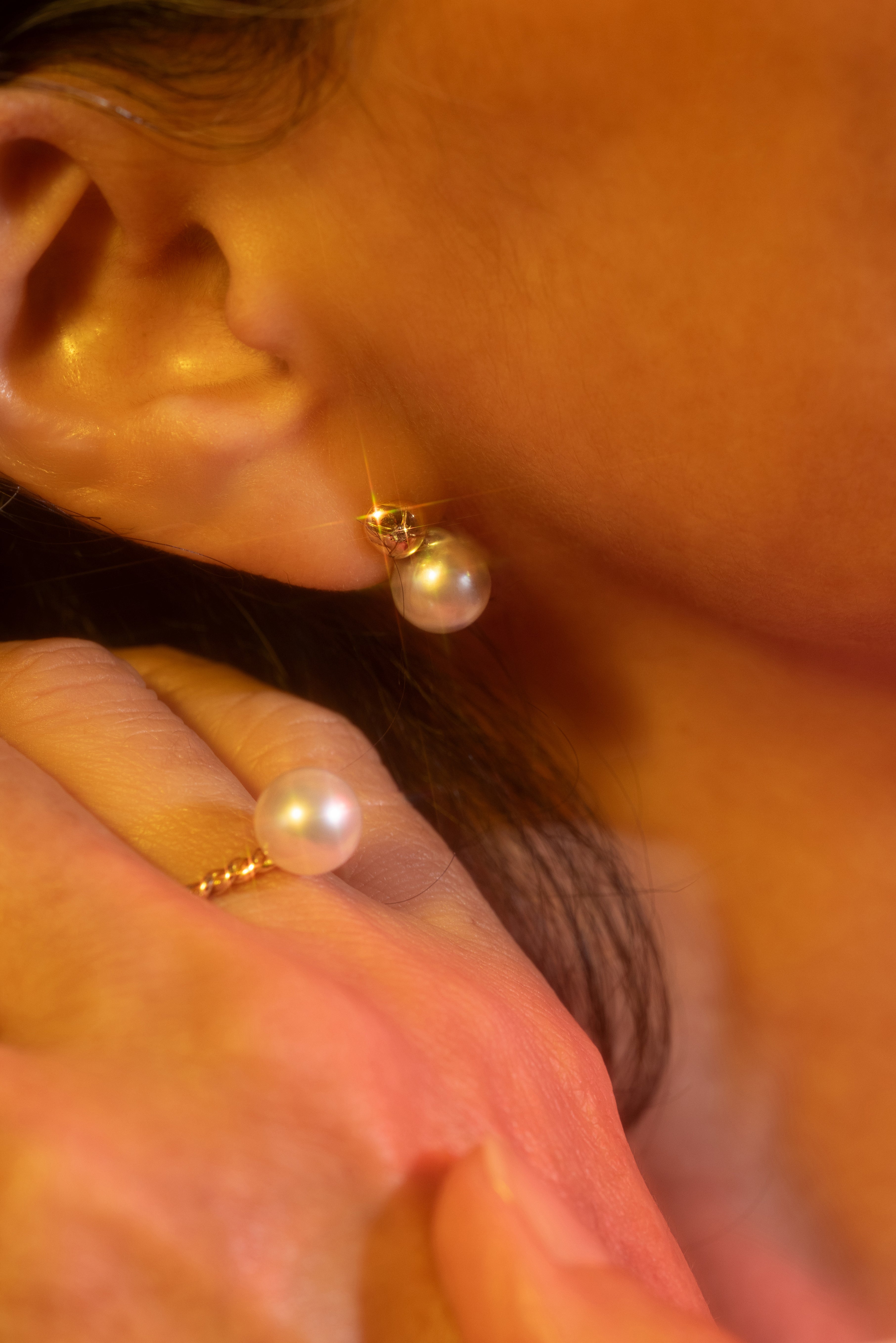 Model wears pearl earrings and a ring from the Giftable Pieces collection