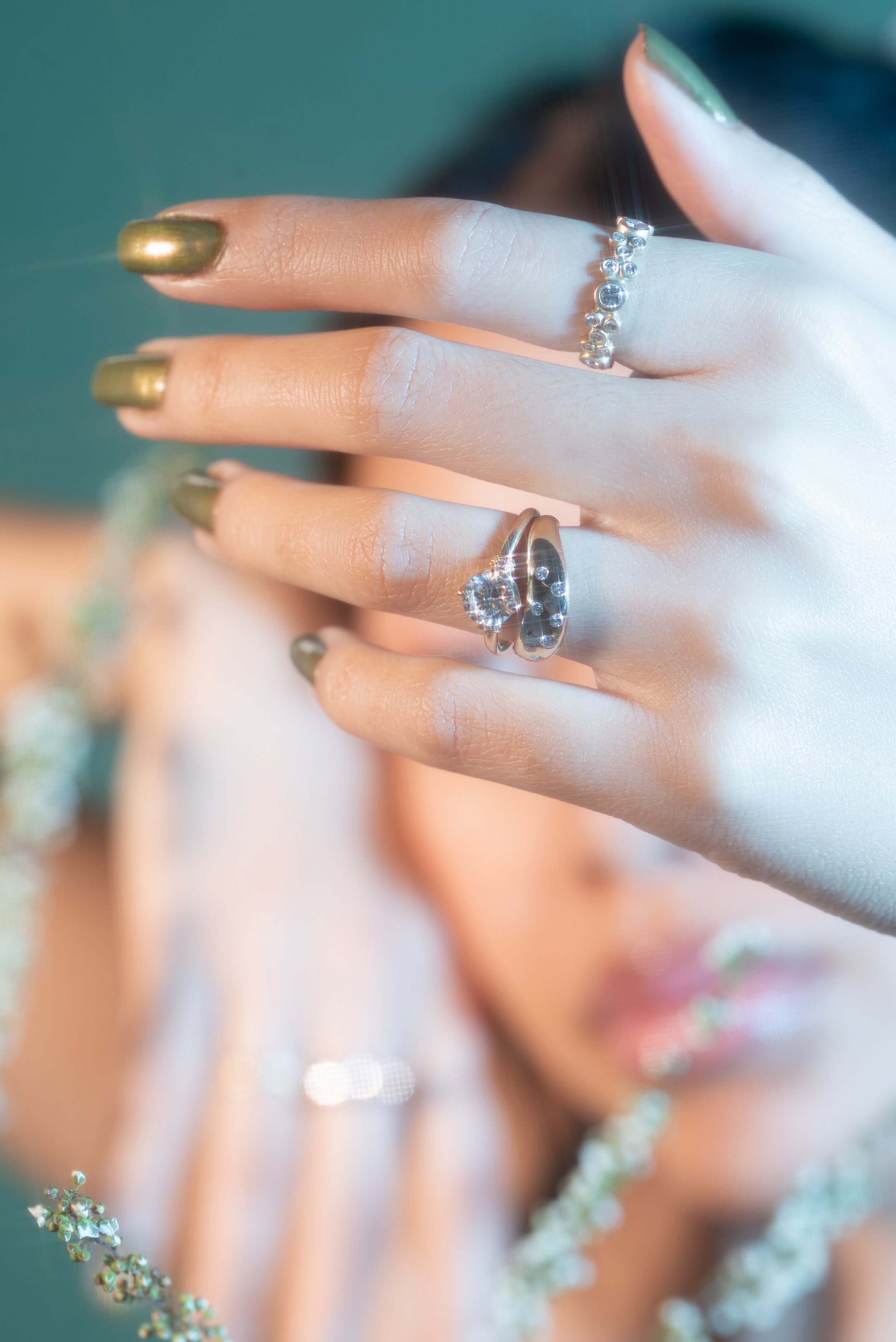 Close-up of a hand wearing multiple rings with a blurred background