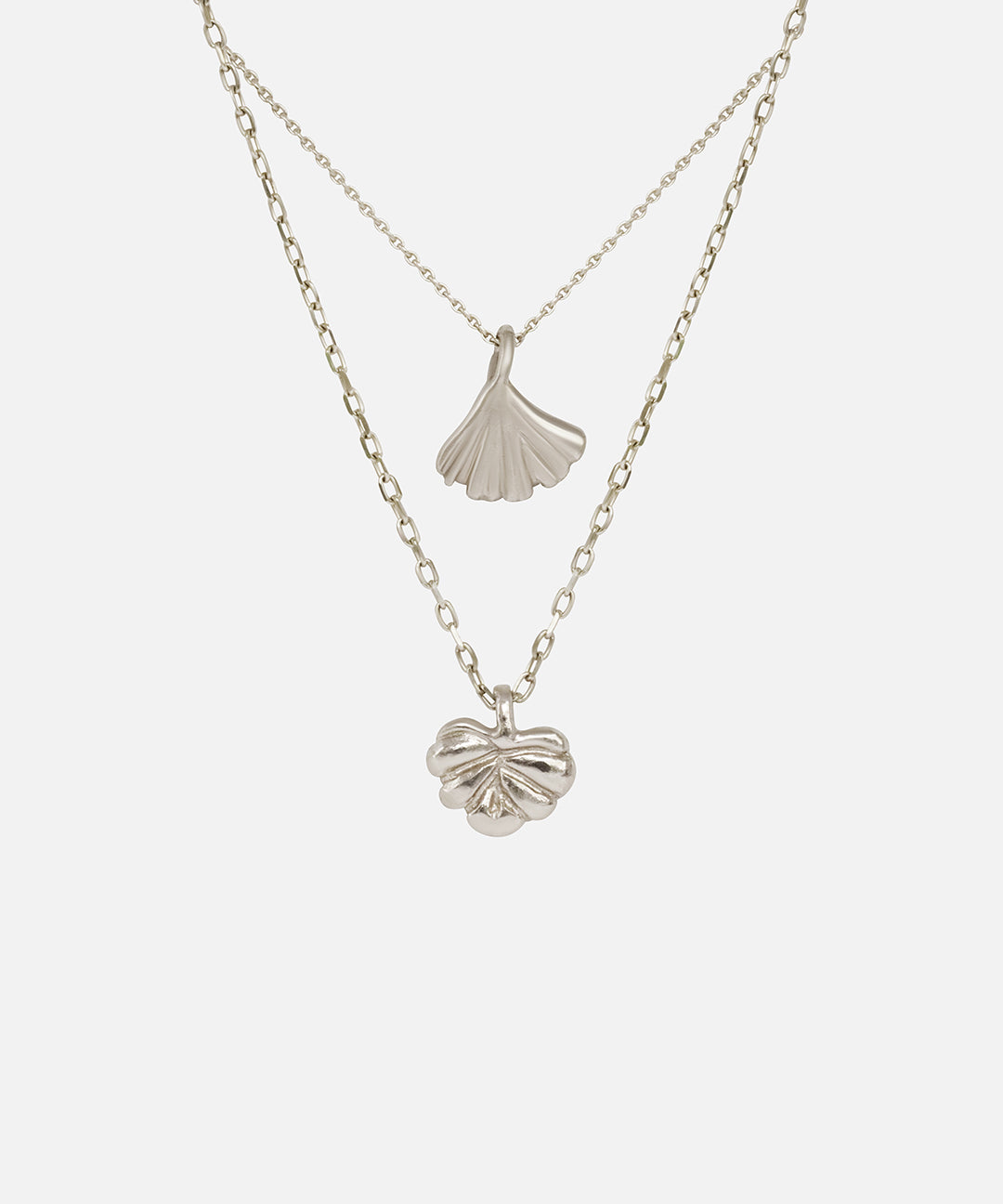 Front view of Ginkgo Necklace in 14k white gold and Lotus Necklace in 14k white gold hanging together