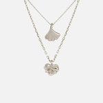 Front view of Ginkgo Necklace in 14k white gold and Lotus Necklace in 14k white gold hanging together