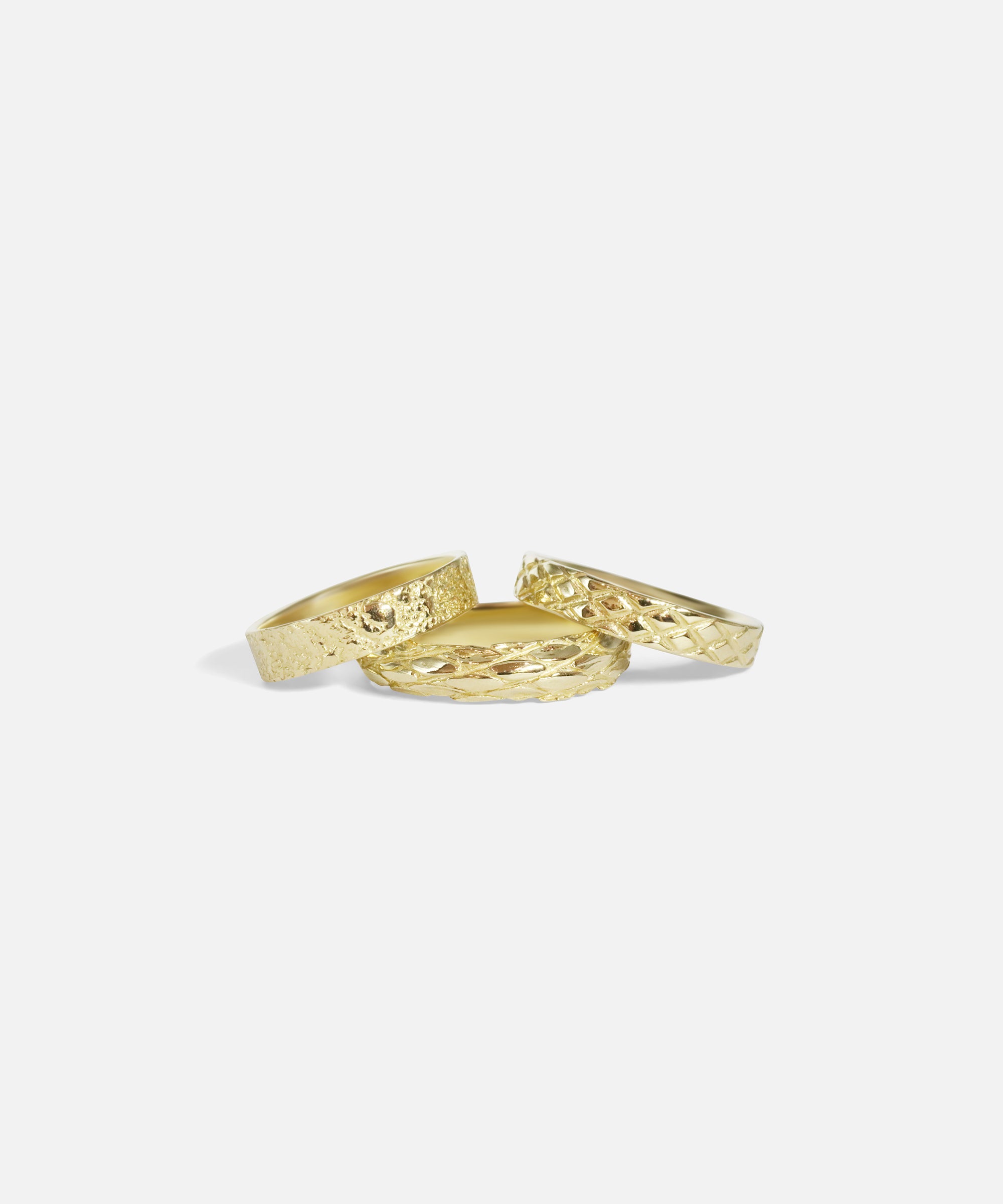 Group shot of Petra Band in 14k yellow gold, Harlequin Band in 14k yellow gold, and Scales Band in 14k yellow gold by Ides