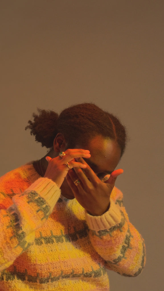 Model wears Dome / Emerald Ring on middle finger alongside other featured jewelry