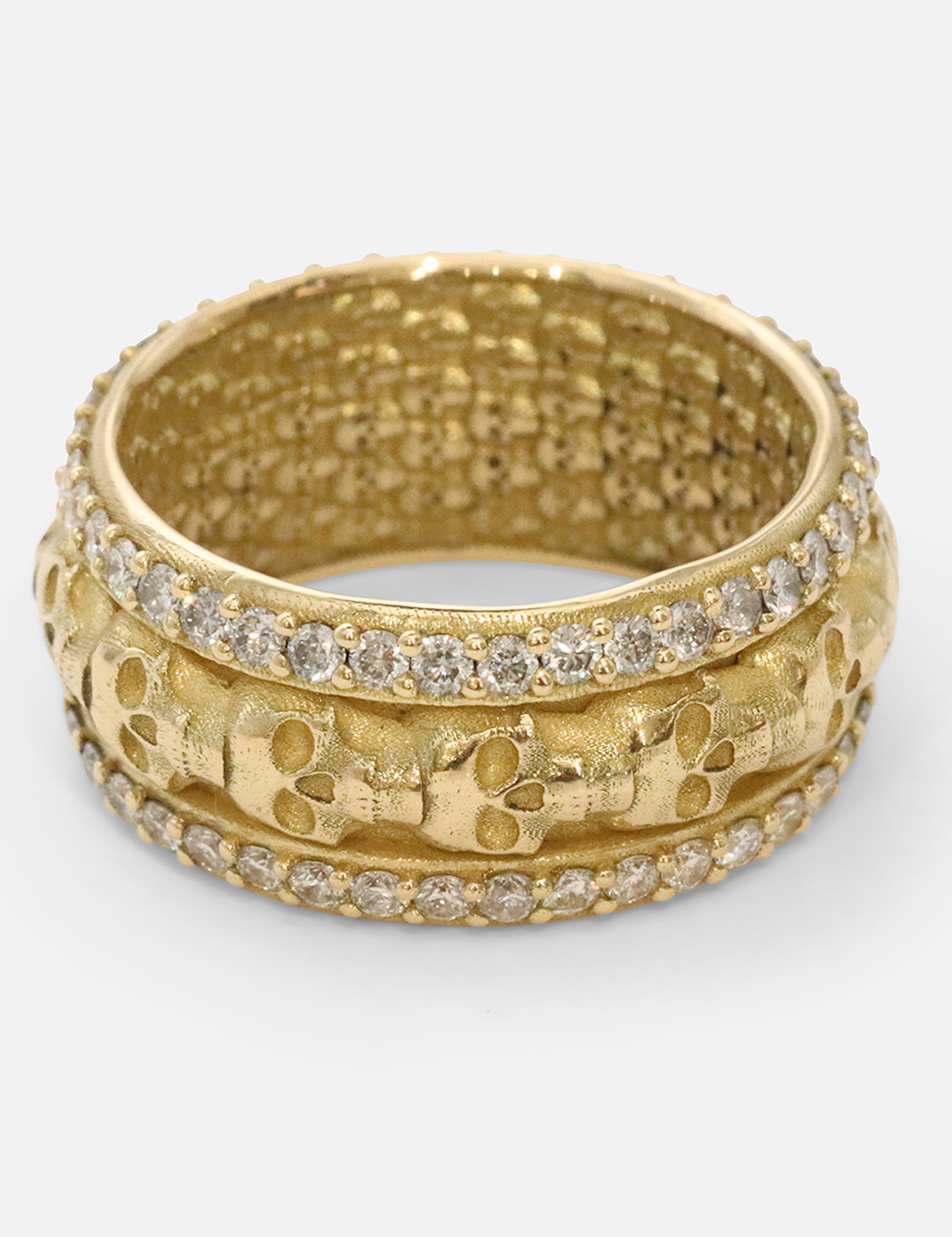 Angled view of Skulls In A Line Band / Pave White Diamonds by Fitzgerald Jewelry in 18k yellow gold