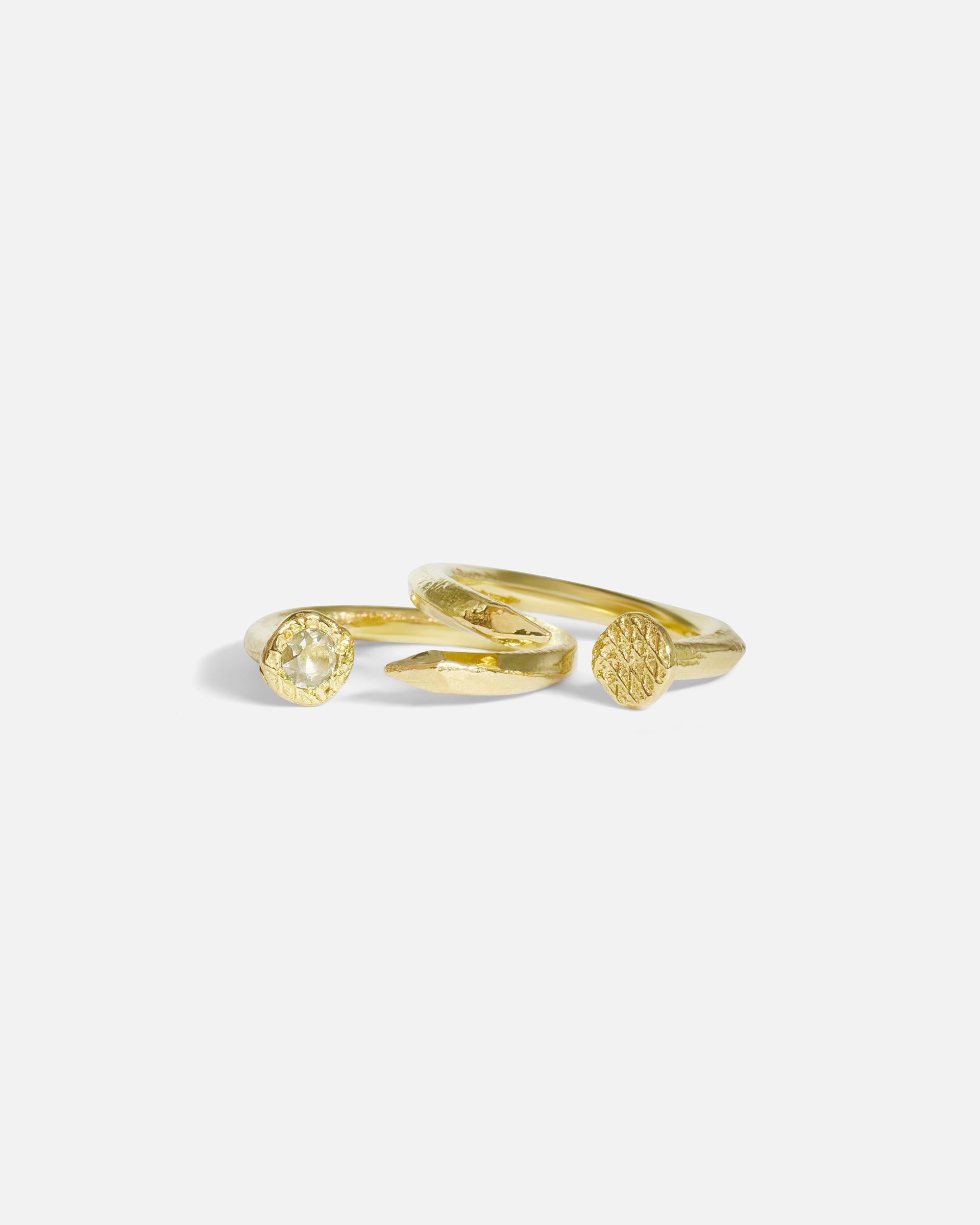 Group stacked shot of Twisted Nail Ring in 14k yellow gold and Diamond Twisted Nail Ring in 14k yellow gold by Ides