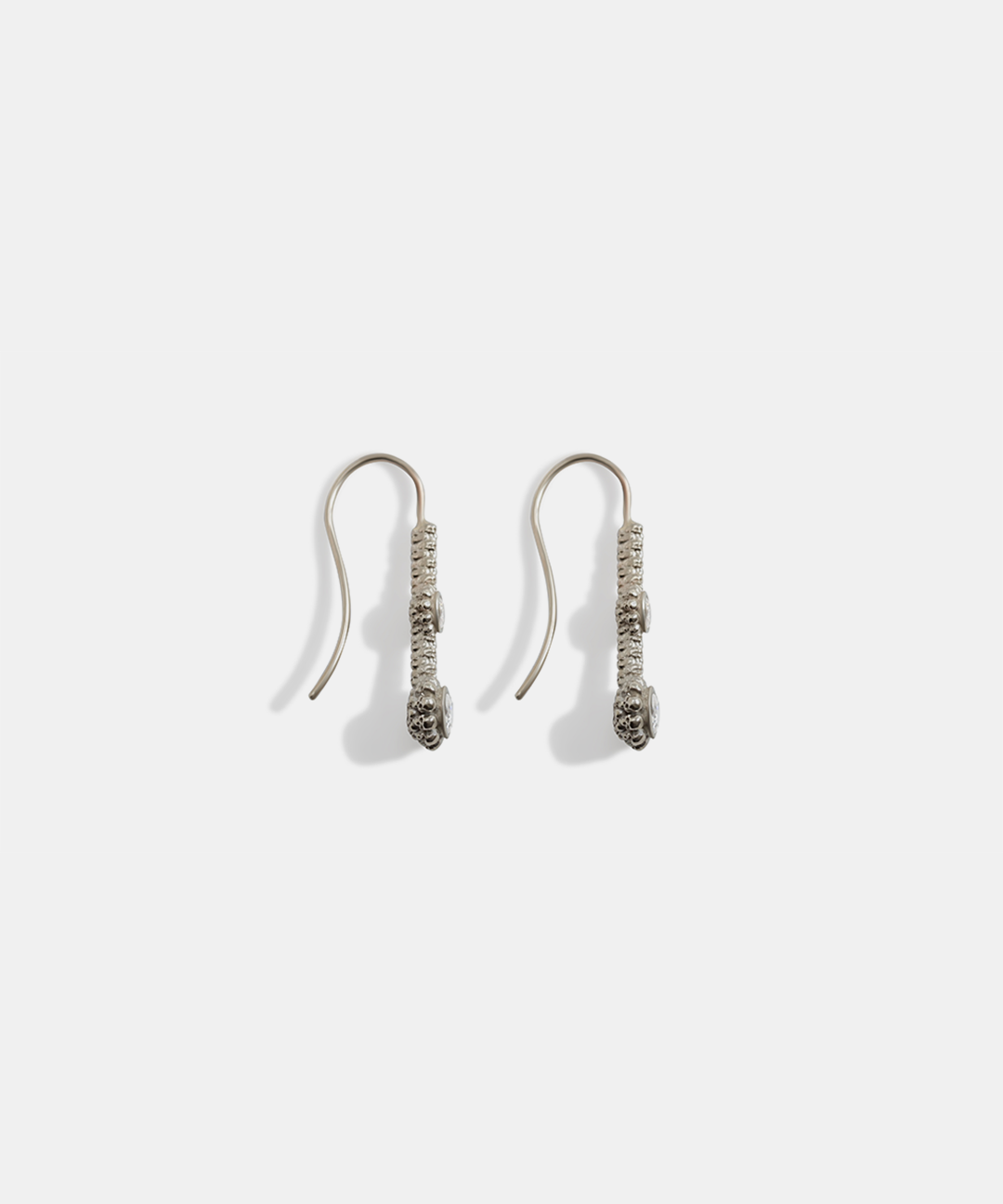 Side view of Skull Double Drop	Earrings in 18k white gold