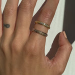 Model wears Skulls In A Line Band / Prong White Diamonds and Skulls in a Line Band stacked on index finger