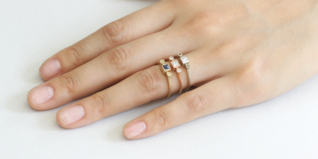 Model hand shot of three Melee 27 versions with various gemstones